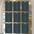 Set of table assignment cards on a decorative mirror with floral decorations.