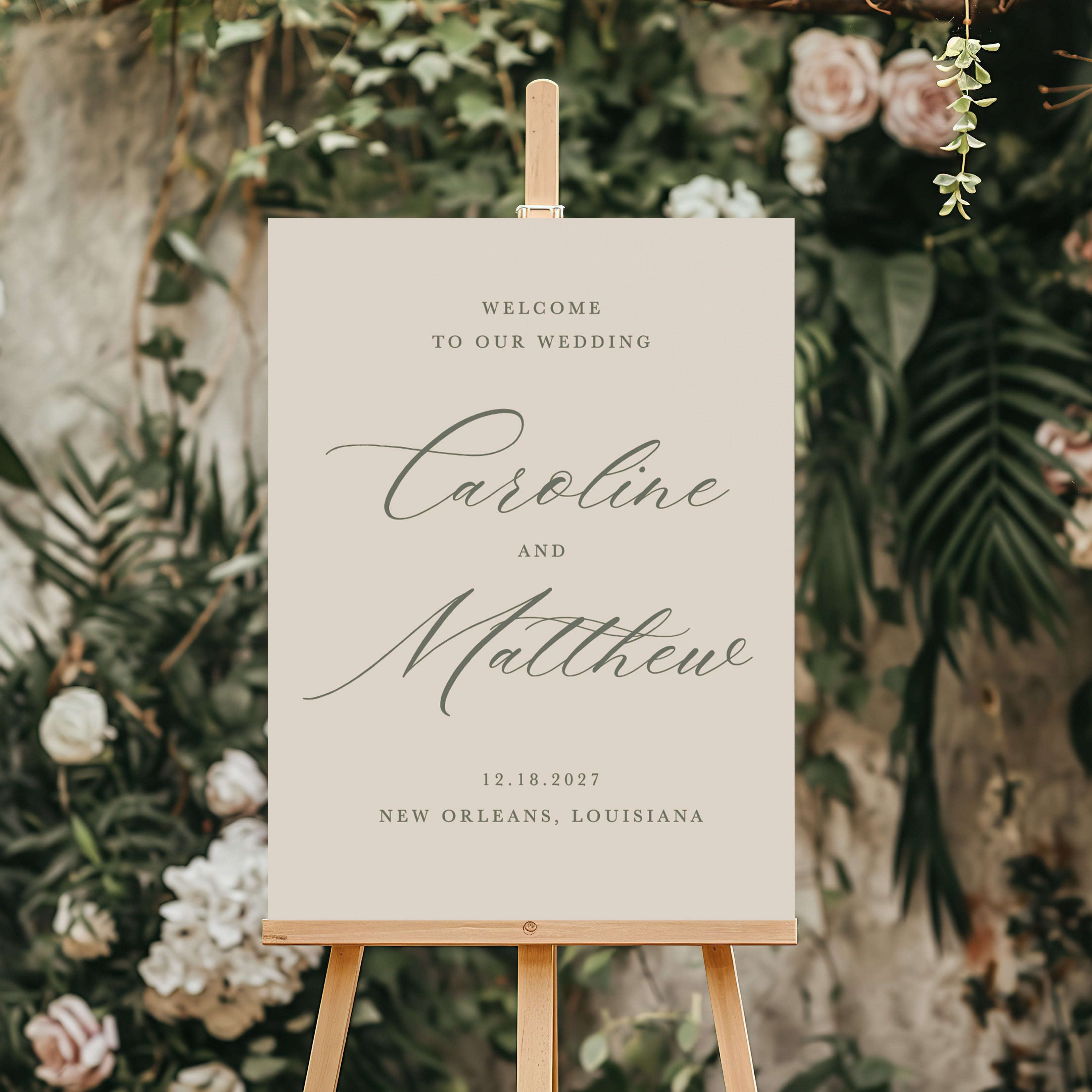 Wedding welcome sign on an easel with floral and greenery background